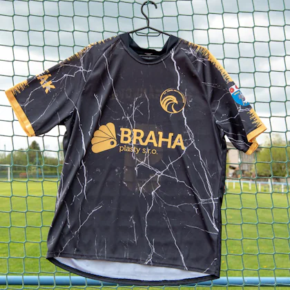 Camiseta de fútbol colgada en la red de una portería
