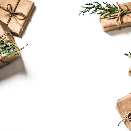 Varios regalos pequeños envueltos en papel kraft con ramitas de pino